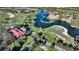 Sweeping aerial perspective of the golf course community with lush landscaping, scenic waterways, and meticulously manicured greens at 7728 Club Ln, Sarasota, FL 34238