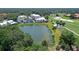 Stunning aerial view of the home, nestled on a lush lot with a pond and golf course views at 7728 Club Ln, Sarasota, FL 34238