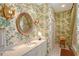 Elegant bathroom with bright countertop, patterned wall paper and decorative fixtures at 7728 Club Ln, Sarasota, FL 34238