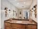 Elegant bathroom vanity with granite countertop, ornate sconces, and a large mirror at 7728 Club Ln, Sarasota, FL 34238