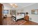 Charming bedroom featuring a four-poster bed, built-in bookshelves, and hardwood floors at 7728 Club Ln, Sarasota, FL 34238