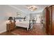 Beautiful bedroom featuring hardwood floors, a four-poster bed, and antique furniture at 7728 Club Ln, Sarasota, FL 34238