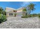 This exterior view showcases a two-story home with a beautiful paver driveway and attached two-car garage at 7728 Club Ln, Sarasota, FL 34238