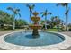 Beautiful tiered fountain set amidst manicured grounds and mature palm trees, creating a serene and picturesque setting at 7728 Club Ln, Sarasota, FL 34238