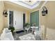 Charming front porch with white seating set, stylish sconces, and tiled floor offers a warm welcome at 7728 Club Ln, Sarasota, FL 34238