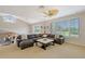 Cozy second-floor living room with large windows providing serene views, centered around a comfortable sectional sofa at 7728 Club Ln, Sarasota, FL 34238