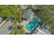 Aerial view of a private pool and patio with tropical landscaping, surrounded by mature trees and lush greenery at 7728 Club Ln, Sarasota, FL 34238