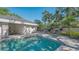 Inviting backyard pool with lounge seating and lush tropical landscaping, perfect for relaxation and outdoor entertaining at 7728 Club Ln, Sarasota, FL 34238
