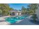 Sparkling community pool featuring ample lounge seating, a covered seating area, and mature landscaping at 7728 Club Ln, Sarasota, FL 34238