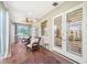 This is a sunroom with wood floors, a ceiling fan and sliding glass doors at 7728 Club Ln, Sarasota, FL 34238