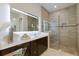 A modern bathroom featuring a large, lighted mirror over the vanity and a glass-enclosed shower at 8133 Grande Shores Dr, Sarasota, FL 34240