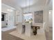 Dining room with white chairs, a modern chandelier, lots of natural light, and an artistic wall hanging at 8133 Grande Shores Dr, Sarasota, FL 34240