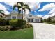 Beautiful, light grey two-story home with a large palm tree and paved driveway at 8133 Grande Shores Dr, Sarasota, FL 34240