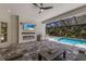 Covered lanai with electric fireplace, grill, tv, and comfortable seating overlooking the pool at 8133 Grande Shores Dr, Sarasota, FL 34240