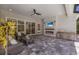 Covered lanai with stone pavers, electric fireplace, grill, tv, and comfortable seating at 8133 Grande Shores Dr, Sarasota, FL 34240
