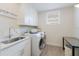 Bright laundry room with modern appliances, stylish cabinets, and a convenient utility sink at 8133 Grande Shores Dr, Sarasota, FL 34240