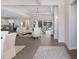 Bright and airy living room featuring wood-look floors, an elegant chandelier, and access to the pool area at 8133 Grande Shores Dr, Sarasota, FL 34240