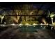 Inviting pool area at night with beautiful landscape lighting in a screened enclosure at 8133 Grande Shores Dr, Sarasota, FL 34240