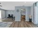 Open living room with wood flooring and light blue walls showing access to the kitchen and a front door entry way at 816 Wabash Rd, Venice, FL 34293