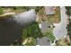 Aerial view of home adjacent to water with luscious landscaping and a driveway with red sports car at 8808 44Th Avenue W Dr, Bradenton, FL 34210