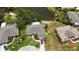 An aerial perspective of a home adjacent to a lake, complemented by mature landscaping and a vibrant red car in the driveway at 8808 44Th Avenue W Dr, Bradenton, FL 34210