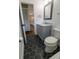Bathroom with hexagon tile flooring, gray vanity with marble top and view into hallway and kitchen at 8808 44Th Avenue W Dr, Bradenton, FL 34210