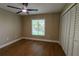 Bedroom featuring updated ceiling fan, neutral paint, wood flooring, base trim, and windows at 8808 44Th Avenue W Dr, Bradenton, FL 34210