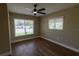 Bedroom featuring updated ceiling fan, neutral paint, wood flooring, base trim, and windows at 8808 44Th Avenue W Dr, Bradenton, FL 34210
