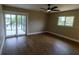 Bedroom with wood flooring, ceiling fan, and access to a screened outdoor space at 8808 44Th Avenue W Dr, Bradenton, FL 34210