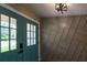 Inviting entryway featuring a teal front door and a decorative accent wall with modern lighting at 8808 44Th Avenue W Dr, Bradenton, FL 34210