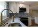 Modern kitchen featuring a stainless steel sink, patterned backsplash, quartz countertop and wood flooring at 8808 44Th Avenue W Dr, Bradenton, FL 34210