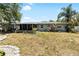 Expansive backyard showcasing lush lawn, mature trees, and the home's exterior at 10827 Village Green Ave, Seminole, FL 33772