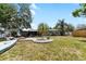 Large backyard featuring lush lawn, mature trees, home's rear exterior and plantings at 10827 Village Green Ave, Seminole, FL 33772