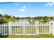 White picket fence encloses the property with serene views of the tranquil lake and lush greenery at 10827 Village Green Ave, Seminole, FL 33772