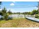 Property boasts tranquil waterfront views, white picket fence, and a kayak for enjoying the serene lake at 10827 Village Green Ave, Seminole, FL 33772