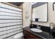 Cozy bathroom with a dark wooden vanity, granite top and a full bathtub behind a decorative curtain at 10827 Village Green Ave, Seminole, FL 33772