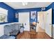 Blue bedroom features hardwood floors, a window, a closet and a door leading to another room at 10827 Village Green Ave, Seminole, FL 33772