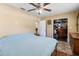Cozy bedroom featuring wood floors, ceiling fan, and a closet at 10827 Village Green Ave, Seminole, FL 33772