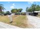 Quaint home on a lot with mature landscaping and a long gravel driveway at 10827 Village Green Ave, Seminole, FL 33772