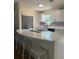 Renovated kitchen featuring white cabinets, countertops, modern backsplash, and stainless steel appliances at 10827 Village Green Ave, Seminole, FL 33772