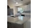 Updated kitchen with granite countertops, white cabinets, modern backsplash, and stainless steel appliances at 10827 Village Green Ave, Seminole, FL 33772