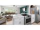 Open-concept kitchen and living area with stainless steel appliances and eat-in kitchen island at 10827 Village Green Ave, Seminole, FL 33772