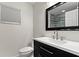 Modern bathroom features a black vanity with a white countertop, a sink, a toilet, and a mirror at 111 Whispering Sands Cir # V38, Sarasota, FL 34242