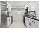 Renovated kitchen features white cabinets, stainless steel appliances, and a stylish backsplash at 111 Whispering Sands Cir # V38, Sarasota, FL 34242