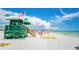 Green lifeguard stand overlooking a pristine beach with calm turquoise water and beachgoers enjoying the summer at 111 Whispering Sands Cir # V38, Sarasota, FL 34242