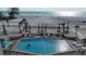 Outdoor pool surrounded by palm trees, beach, and ocean views at 111 Whispering Sands Cir # V38, Sarasota, FL 34242