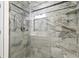 Updated shower with tiled walls, a glass door, a built-in shelf, and a shower head at 111 Whispering Sands Cir # V38, Sarasota, FL 34242