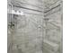 Updated shower featuring tiled walls, a glass door, a built-in shelf, and a shower head at 111 Whispering Sands Cir # V38, Sarasota, FL 34242