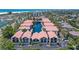An aerial view shows lush landscaping, beach proximity, tennis courts, and a pond for these condos at 1159 Lake House Cir # C120, Sarasota, FL 34242