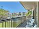 Private balcony overlooking a pond with chairs and tables offering a serene outdoor space at 1159 Lake House Cir # C120, Sarasota, FL 34242